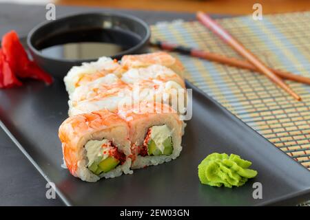 Sushi-Rolle mit Garnelenfleisch auf schwarzem Keramikplatte bedeckt Stockfoto