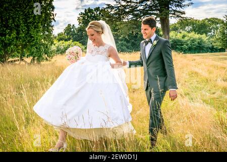 Braut und Bräutigam glücklich zusammen auf dem Feld von langem Gras Stockfoto