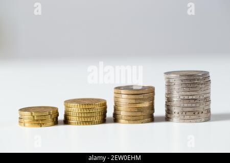 Haufen von Euro-Münzen gedeihen auf weißem Hintergrund. Stockfoto
