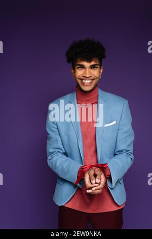 Happy african american Mann mit rotem Band auf lila gebunden Stockfoto