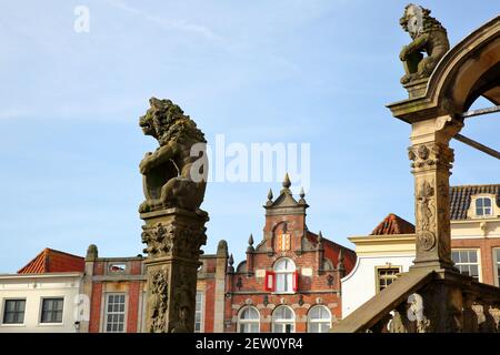 Nahaufnahme von zwei Löwenstatuen am Eingang des Stadhuis (Rathaus, datiert von 1450), mit historischen Häusern, Gouda, Südholland, Niederlande Stockfoto