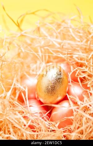 Helle fröhliche ostern Hintergrund, goldfarbene Eier in Heu Nest Nahaufnahme, Pastellfarben Stockfoto
