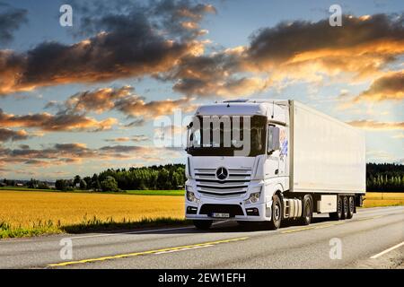 Der weiße Mercedes-Benz Actros 1845 zieht im Sommer den FRC-Sattelauflieger auf der Autobahn 2 unter dem schönen Himmel der Dämmerung. Jokioinen, Finnland. August 28 2020 Stockfoto