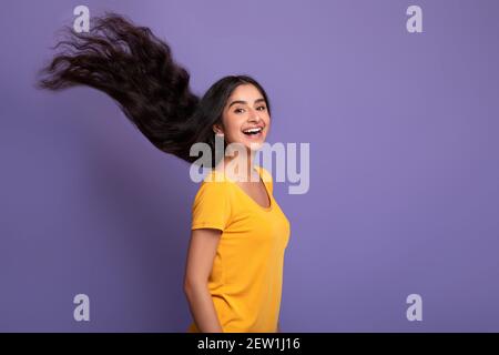 Indische Frau posiert mit langen fliegenden Haaren im Studio Stockfoto