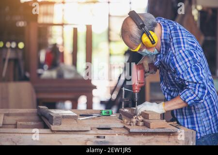 Zimmermann, Senior Mann Schleifen Holzzaun am Arbeitsplatz mit Arbeitswerkzeug Stockfoto