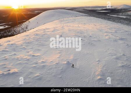 Finlande, Lappland, Kittila, Schneeschuhwanderung in der Taiga des Pallas-Yllästunturi National Park bei Sonnenaufgang (Luftaufnahme) Stockfoto