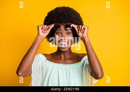 Foto-Porträt von aufgeregt Mädchen anheben Brille isoliert auf Lebhaft gelber Hintergrund Stockfoto