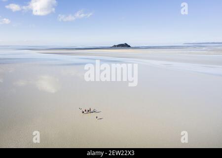 Frankreich, Manche, der Mont-Saint-Michel, Gruppe, die die Bucht von Mont-Saint-Michel in der Nähe des Felsens von Tombelaine überquert (Luftaufnahme) Stockfoto