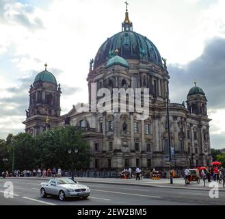 BERLIN, DEUTSCHLAND - 21. Feb 2021: Der Dom von Belin, Berliner Dom auf dem Hintergrund eines dramatischen Himmels mit einem Mercedes Cabrio davor. Stockfoto