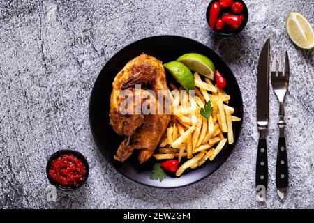 Halb geröstetes Huhn Piri Piri mit pommes Frites, Draufsicht Stockfoto