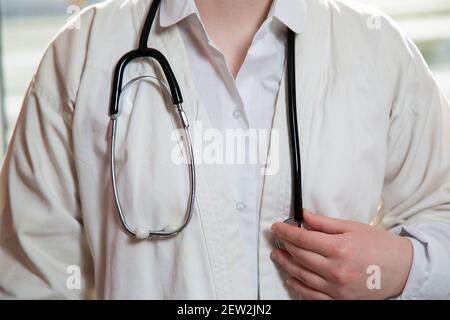 Junge Ärztin in medizinischer Kleidung mit Stethoskop. Stockfoto