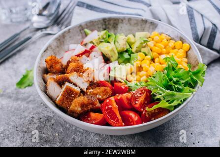 Gesundes Mittagessen Biddha Schüssel. Avocado, Huhn, Tomate, Rettich, Mais, Grüne Blätter Gemüsesalat. Konkrete Hintergrund Nahaufnahme Stockfoto