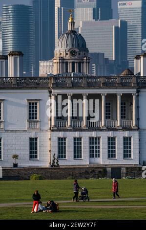 London, Großbritannien. März 2021, 2nd. Die Menschen genießen das Frühlingswetter und die Aussicht auf Canary Wharf, das Navalk College und das geschlossene Maritime Museum vom Greenwich Park, während London 3 gesperrt bleibt. Kredit: Guy Bell/Alamy Live Nachrichten Stockfoto