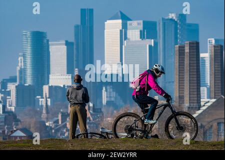 London, Großbritannien. März 2021, 2nd. Die Menschen genießen das Frühlingswetter und die Aussicht auf Canary Wharf im Greenwich Park, während London 3 gesperrt bleibt. Kredit: Guy Bell/Alamy Live Nachrichten Stockfoto