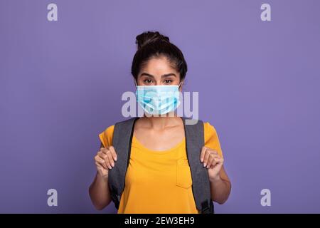 Happy indian Studentin tragen Rucksack und Gesichtsmaske Stockfoto