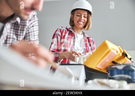 Lächelnde Arbeiterin in einem Schutzhelm und ein Ingenieur Stockfoto