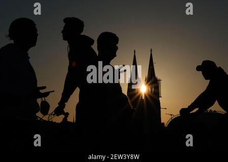 Köln, Deutschland. März 2021, 02nd. Junge Leute laufen und fahren in der Abendsonne an der Kathedrale vorbei. Am Mittwoch (03,03.2021) werden Bund und Länder darüber diskutieren, wie die Maßnahmen gegen die Corona-Pandemie weitergehen sollen. Quelle: Oliver Berg/dpa/Alamy Live News Stockfoto