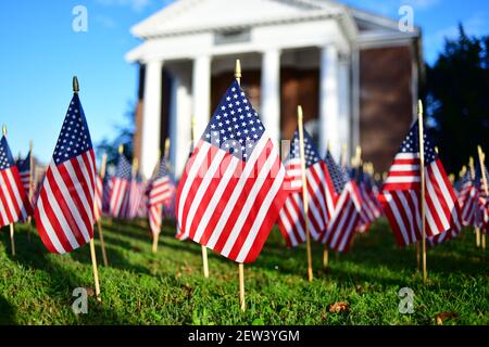 Viele Miniatur-US-Flaggen auf dem Gras vor gesetzt Von einer Gedenkkapelle aus der Nähe in einem niedrigen Winkel Mit Kapelle im Hintergrund Stockfoto