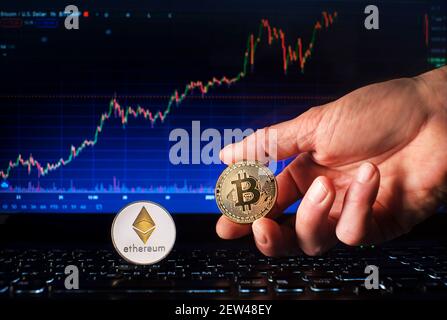 Business Männer halten Bitcoin und ethereum Münze mit Computer Trading Chart Hintergrund. Bitcoin und Altcoin das wichtigste Kryptowährungskonzept Stockfoto