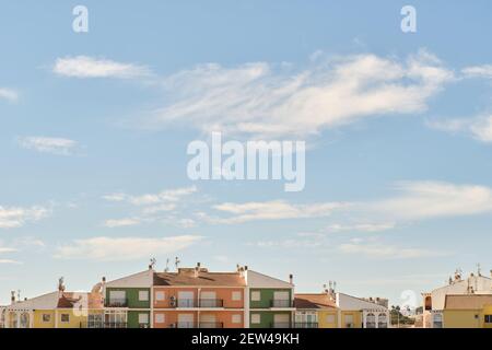 Außenansicht der mehrfarbigen modernen Wohngebäude Skyline vor flauschigen blauen Himmel Hintergrund, sonnigen Tag. Torrevieja, Stadt, Costa Blanca. Sp Stockfoto