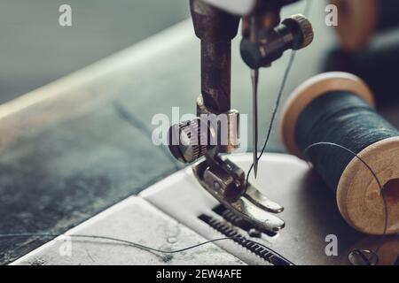 Nahaufnahme der Nähnadel. Spule des Fadens auf Arbeitsteil der antiken Nähmaschine. Stockfoto