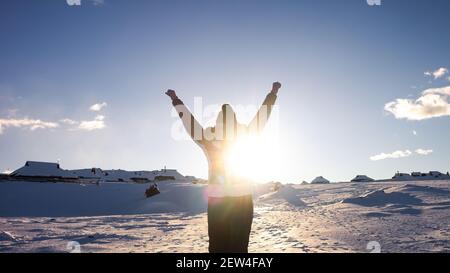 Frau auf Velika planina mit Hirten Hütten im Winter mit Schnee bedeckt. Stockfoto