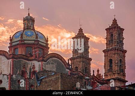 Kirche Santa Prisca aus dem 18th. Jahrhundert mit ihren Churrigueresque Zwillingstürmen im kolonialen Stadtzentrum von Taxco de Alarcón bei Sonnenuntergang, Guerrero, Mexiko Stockfoto