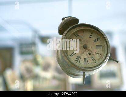 Sehr alter Goldener Wecker mit Glocke, die im schwebt Luft mit hellem Hintergrund Stockfoto