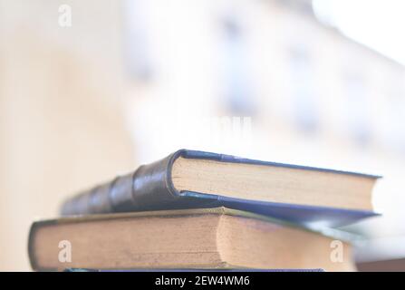 Mehrere alte und leicht abgenutzte Bücher in einem Turm gestapelt Auf einem Schreibtisch Stockfoto