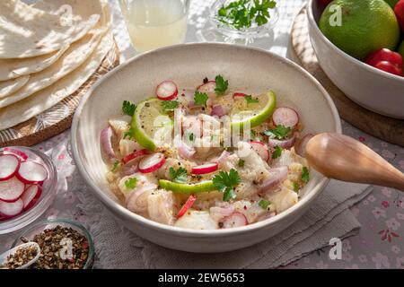 Nahaufnahme einer peruanischen Ceviche mit Fischstücken und Zitronen Stockfoto