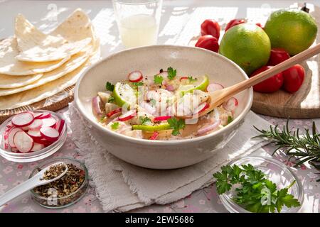 Nahaufnahme einer peruanischen Ceviche mit Fischstücken und Zitronen Stockfoto