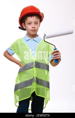 Junge in Konstruktion grüne Weste und orange Helm Holding Paint Walze auf weißem isoliertem Hintergrund Stockfoto