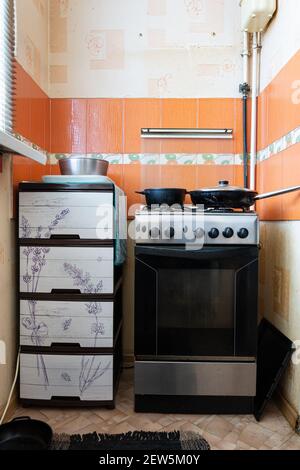 Gasherd in einer alten Küche und eine Plastikbox Stockfoto