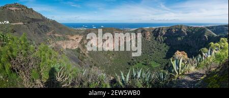 Panoramablick auf die vulkanische Landschaft des Kraters Caldera de Bandama und des Pico de Bandama mit Rundwanderweg. Gran Canaria, Spanien. Sonniger Tag, blau Stockfoto