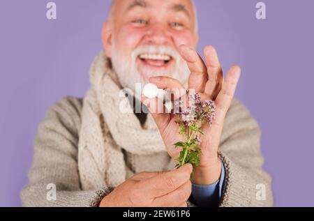 Medizin Kräuter, Gesundheitswesen, Pharmazeutika und Homöopathie. Mann mit Pillen und Kräuterpflanze. Stockfoto