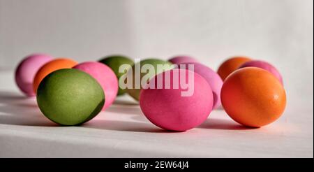 Bunte Hühnereier mit natürlichen Lebensmittelfarben auf einem grauen Hintergrund mit Schatten gemalt. Vorderansicht. Banner. Osterfeiertagskonzept Stockfoto