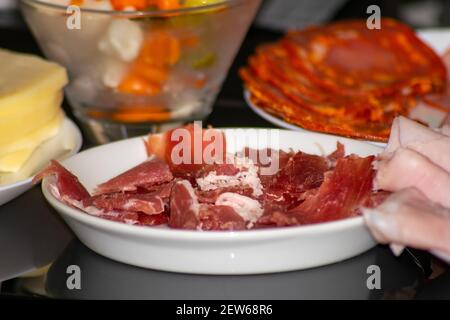 Zubereitung von Raclete Swish Gericht, auch beliebt in Savoie, Frankreich, auf der Grundlage von Käse erhitzen und Abkratzen der geschmolzenen Teil. Stockfoto