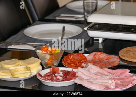 Zubereitung von Raclete Swish Gericht, auch beliebt in Savoie, Frankreich, auf der Grundlage von Käse erhitzen und Abkratzen der geschmolzenen Teil. Stockfoto