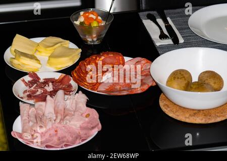 Zubereitung von Raclete Swish Gericht, auch beliebt in Savoie, Frankreich, auf der Grundlage von Käse erhitzen und Abkratzen der geschmolzenen Teil. Stockfoto