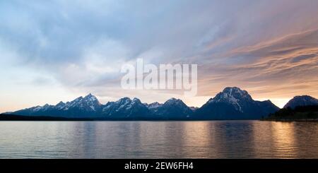 Sonnenuntergang über Jackson Lake im Teton National Park, Wyoming, USA. Mount Moran und Grand Teton beide sichtbar unter wabenden Pastellwolken Stockfoto