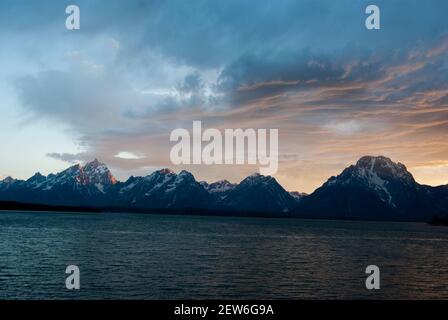 Pastellfarbener Sonnenuntergang über der Teton Range, Jackson Lake im Vordergrund mit Mt Moran und Grand Teton sichtbar über dem See Stockfoto