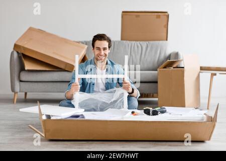 Positive Emotionen der Person, Umzug in neues Haus und Montage Möbel mit eigenen Händen Stockfoto