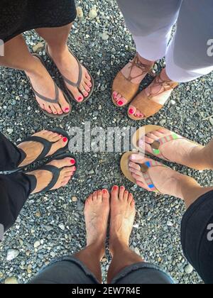 Freunde barfuß Draufsicht. Freunde mittleren Alters bilden einen Kreis mit ihren Füßen. Barfuß und Sandalen. Konzept Freunde, Freundschaft, Vielfalt, anders. Stockfoto