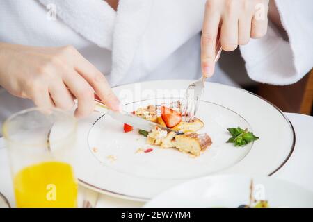 Zugeschnittenes Foto eines Mannes in einem weißen Frottee-Dressing Kleid mit einem Frühstück Stockfoto