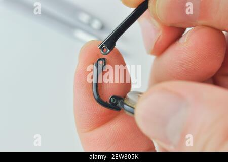 Gebrochene Brille und Schraubendreher auf grauem Hintergrund. Brillen Reparaturkonzept. Stockfoto