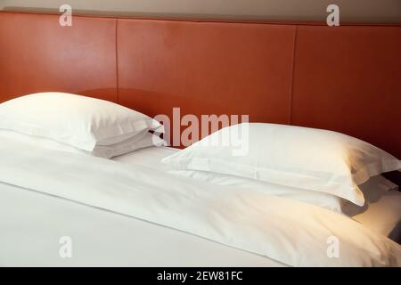 Typisches Hotelzimmer. Doppelbett mit weißer Bettwäsche und zwei Kissen Stockfoto