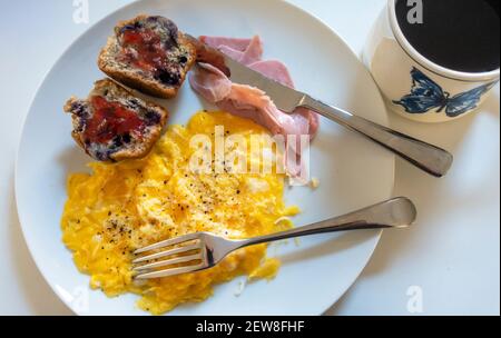 Rührei und Schinken mit einem Blaubeer-Muffin und schwarz Kaffee Stockfoto