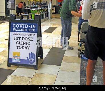 Amerikanische Senioren im Alter von 65 Jahren oder älter stehen während der ersten Welle von COVID-19-Coronavirus-Impfungen, die vom Gesundheitsministerium des Sarasota County an der Westküste Floridas, USA, organisiert wurden, in einem Einkaufszentrum an. Für die 1. Dosis des Moderna-Impfstoffes mit zwei Impfdosen waren online oder telefonisch vereinbarte Termine erforderlich, für die auch eine 2. Dosis vier Wochen später erforderlich war. Das Gesundheitsministerium des Bezirks hatte bis März 2021, ein Jahr nachdem die Weltgesundheitsorganisation (WHO) diese globale Pandemie ausgerufen hatte, Dosen des Impfstoffs in die Oberarme von mehr als 50.000 Menschen injiziert. Stockfoto