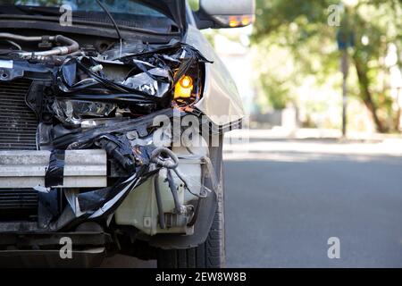 Fahrer Mann Blick auf zerstörte Auto in Autounfall. Mann bedauert über die Befestigung Autoscheinwerfer nach dem Autounfall. Tragische Autounfall. Gefährliche Straße Stockfoto