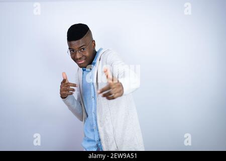 Junger schöner afroamerikanischer Mann in lässiger Kleidung zeigt auf Sie und die Kamera mit Fingern, lächelnd positiv und fröhlich Stockfoto